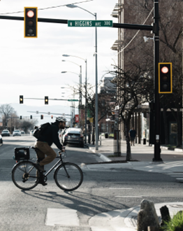 image of bicyclist crossing street at a crosswalk