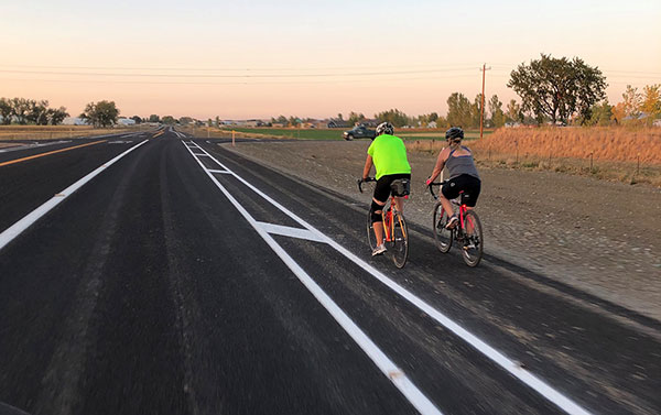 Bicyclists enjoy the bike lane on the newly constructed Five Mile Road
