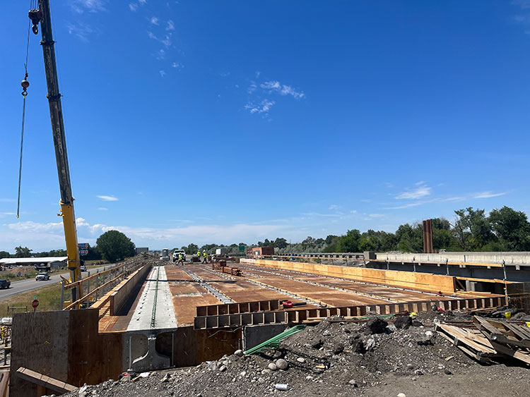 The new bridge deck is being constructed on the eastbound bridge above South 56th Street West. These bridges are being widened to accommodate standard-width shoulders.)