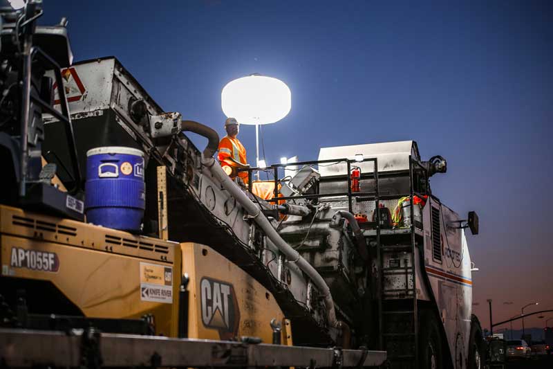 Workers operate milling equipment at night to limit the impact of resurfacing work on the traveling public.