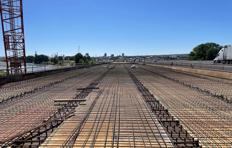 Installation of the bridge deck forming system continues in preparation for pouring concrete. 