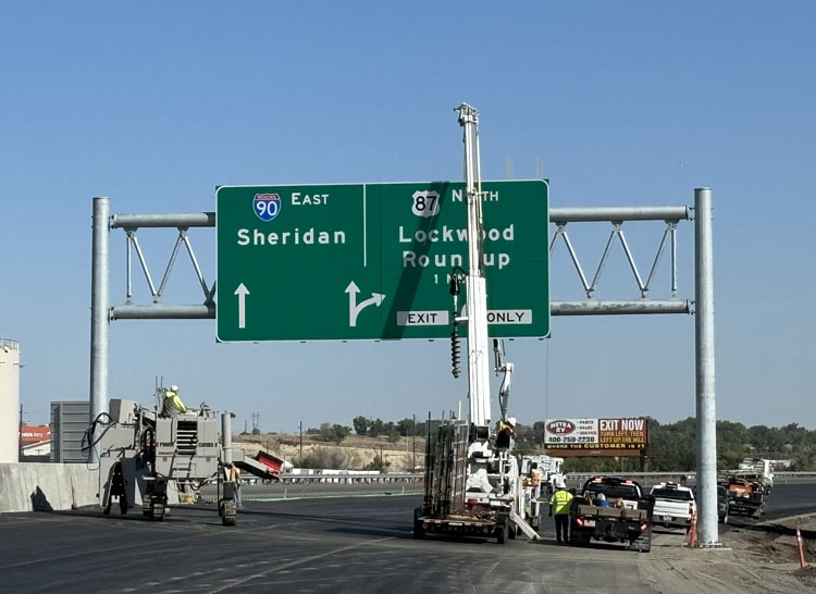 Crews installing highway direction signs