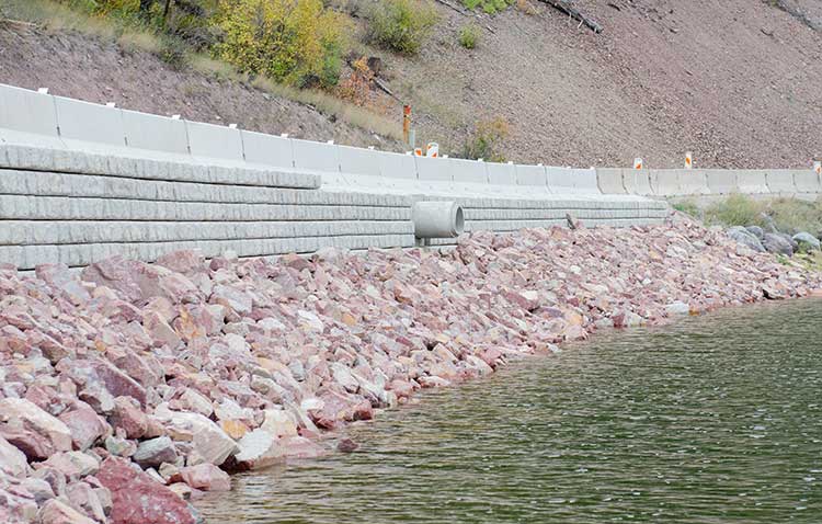 View from Salmon Lake of MT 83 riprap, block retaining wall, and barrier rail. 
